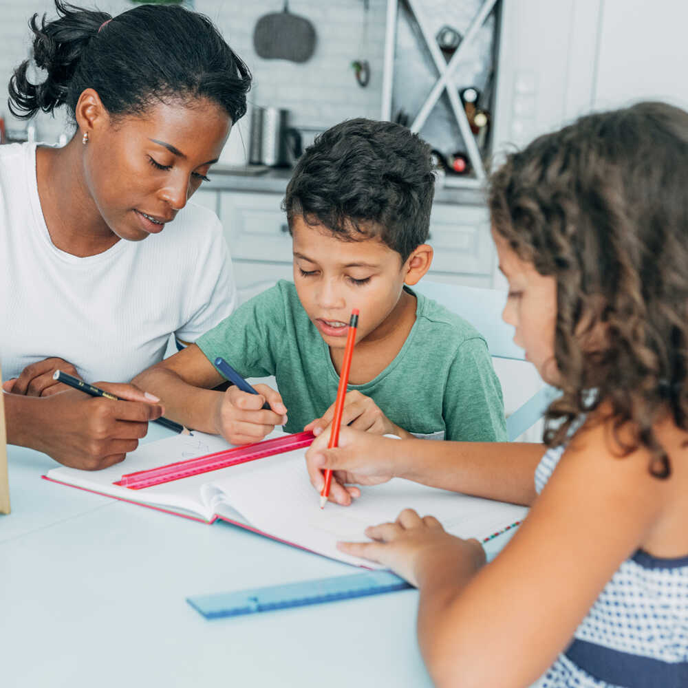 two kids being tutored by an adult