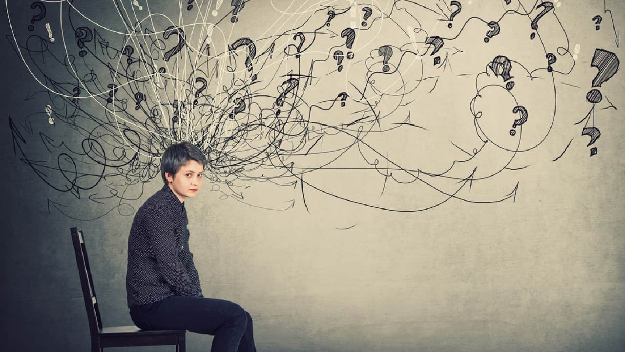 A teenage boy with ADHD sitting on a chair with an illustrated mass of scribbles coming out of his head